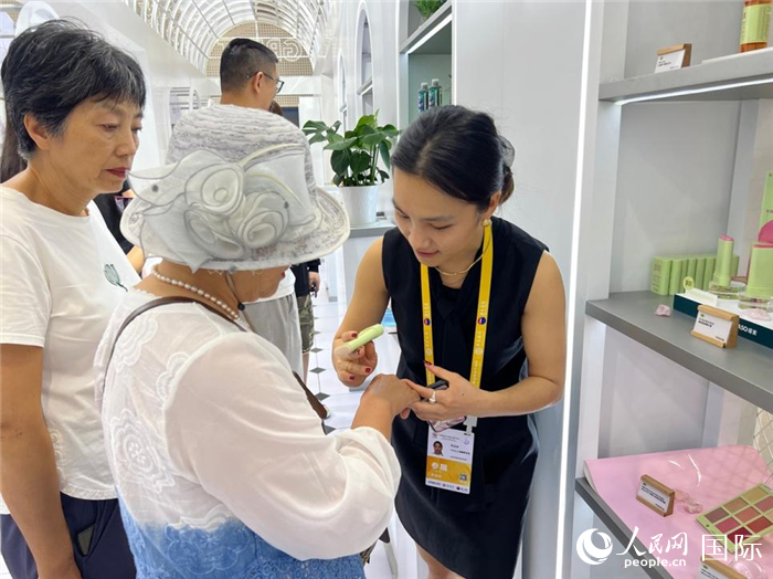 观展群众试用英国馆产品。人民网记者 赵瞳摄