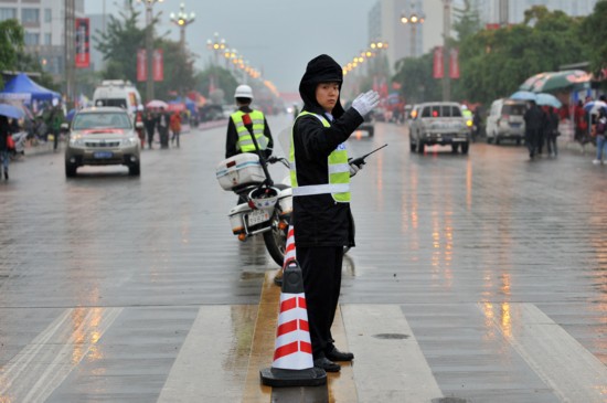 4月23日早上,在芦山县城,雨中指挥交通的交警.