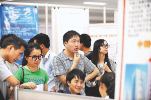 六月五日,几名大学生求职者在杭州市人才市场查看招聘信息.