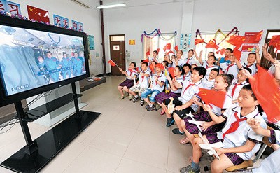 　在安徽合肥市瑶海区和平小学东校的学生们正聚精会神地收看我国首次太空授课。