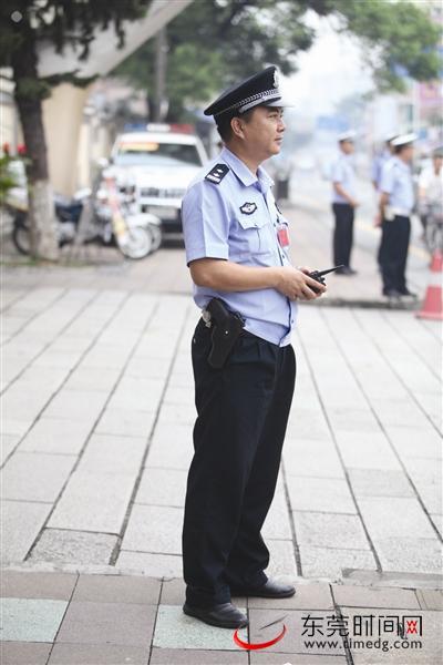 昨日,东莞中学考点外,警方配枪执勤.(记者 王欢摄)