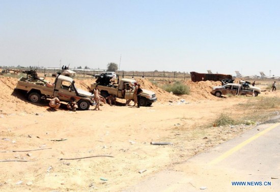 Militiamen stand guard the perimeter of Tripoli International Airport, in Libya, on July 16, 2014. 