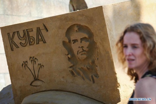 A visitor walks past a sand sculpture displayed during the international festival of sand sculptures in St.Petersburg, Russia, on July 17, 2014.