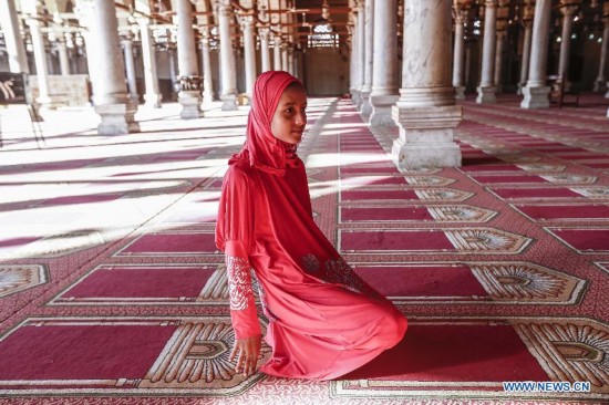 An Egyptian girl gets up after a prayer inside a mosque during the fasting hours in a Ramadan afternoon in Cairo July 16, 2014.