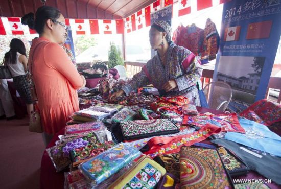 Visitors look through handcrafts during the 'Colorful Guizhou Exhibition' in the Town of Niagara-on-the-Lake, Ontario, Canada, July 22, 2014. 