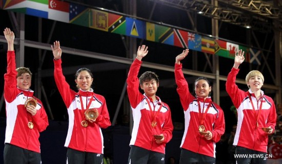 Players of Singapore celebrate their victory on the podium during the awarding ceremony for the women's team final of table tennis at the 2014 Glasgow Commonwealth Games 
