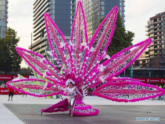 A dressed up competitor perfroms with her float during the King and Queen Competition and Show of the 47th Toronto Caribbean Carnival in Toronto, Canada, July 31, 2014.