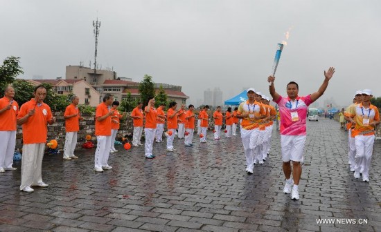 Torch bearer Wang Lei runs with the Olympic torch on the city wall during the Olympic Torch Relay for the Nanjing Youth Olympic Games in Nanjing