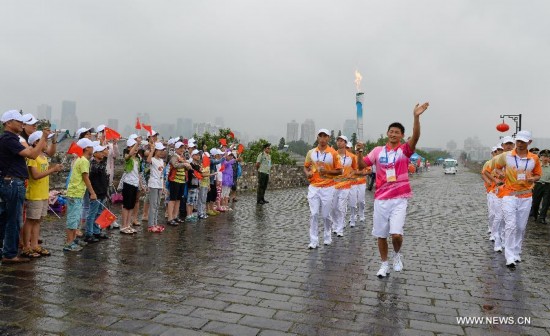 Torch bearer Ding Lianghao runs with the Olympic torch on the city wall during the Olympic Torch Relay for the Nanjing Youth Olympic Games in Nanjing