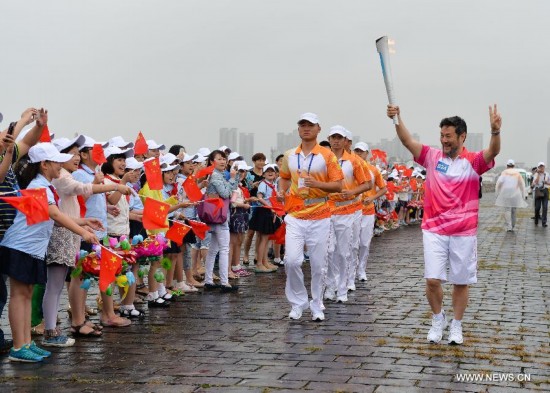 Chen Weiya, chief director of the opening and closing ceremonies of the Nanjing Youth Olympic Games, runs with the Olympic torch on the city wall during the Olympic Torch Relay for the Nanjing Youth Olympic Games in Nanjing