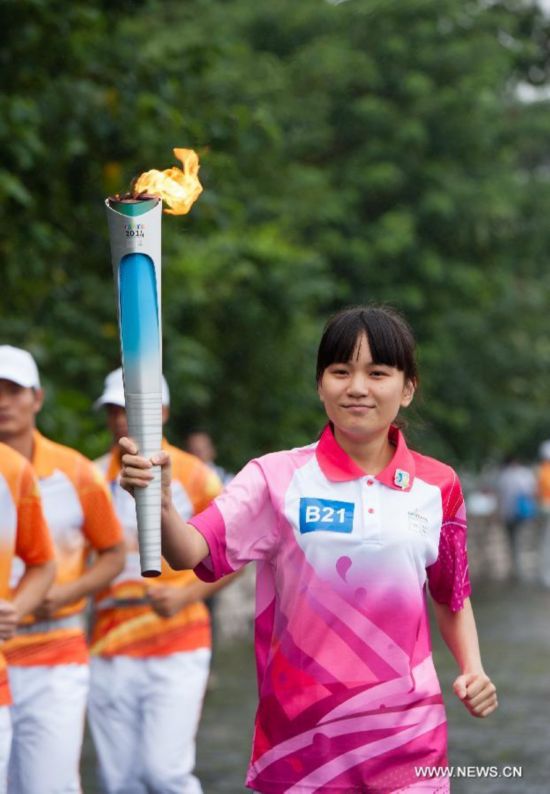 Torch bearer Zhao Li runs with the Olympic torch on the city wall during the Olympic Torch Relay for the Nanjing Youth Olympic Games in Nanjing