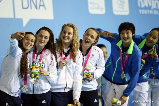 Ahtletes of Great Britain(L) pose for photos with Athletes of China during the awarding ceremony of the women's 4 × 100m medley relay match of swimming event at the 2014 Nanjing Youth Olympic Games