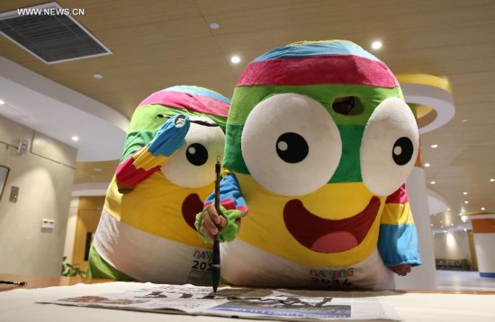 Lele, the mascot of Nanjing 2014 Youth Olympic Games, practice calligraphy in the Main Media Centre of Nanjing 2014 Youth Olympic Games