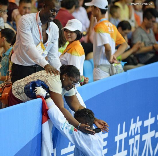 Yoann Miangue(R) of France celebrates with his mother after the men+73kg final of Taekwondo event during Nanjing 2014 Youth Olympic Games in Nanjing, capital of east China’s Jiangsu Province, on Aug. 21, 2014. 