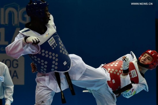 Yoann Miangue(L) of France and Denys Voronovskyy of Ukraine compete in the men+73kg final of Taekwondo event during Nanjing 2014 Youth Olympic Games in Nanjing, capital of east China’s Jiangsu Province, on Aug. 21, 2014. Yoann Miangue won the match. 