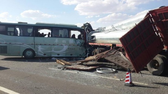 Photo taken on Aug. 26, 2014 shows a bus collided head-on with a truck on a highway in Guazhou County in the city of Jiuquan, northwest China's Gansu Province. Thirteen people were killed in the accident on Tuesday afternoon. The accident occurred at about 12:20 p.m. when the bus broke through the central partition and ran into the opposite lane to crash into the oncoming semi-trailer truck on the highway. The number of injured is still being verified. 