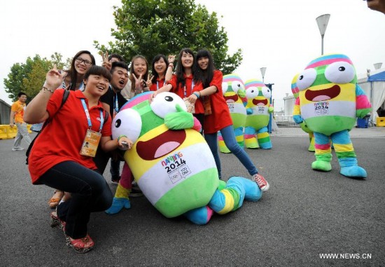 Lele pose with staff to say goodbye to Nanjing 2014 Youth Olympic Games in Nanjing, east China's Jiangsu Province, Aug. 28, 2014. 