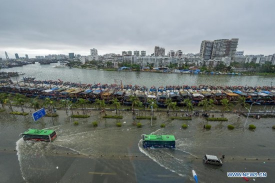 Buses move on flooded road in typhoon-hit Haikou, capital of south China's Hainan Province, Sept. 16, 2014. Seawater flew backward into the city as typhoon Kalmaegi landed in the island province on Tuesday morning. (Xinhua/Jiang Jurong)