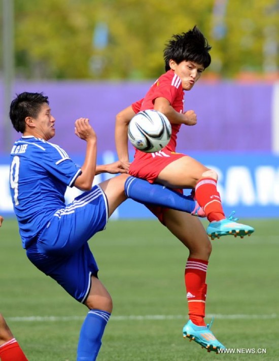 Wang shanshan (R) of China vies for the ball with Lee Hsiu Chin of Chinese Taipei during the women's football first round group B match at the 17th Asian Games in Incheon, South Korea, on Sept. 18, 2014.