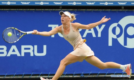 Caroline Wozniacki of Denmark hits a return against Carla Suarez Navarro of Spain during the third round match at the Toray Pan Pacific Open tournament in Tokyo, Japan, Sept. 19, 2014.