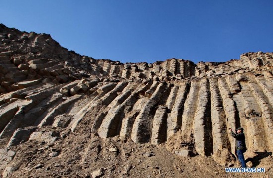 A visitor takes photos of the basalt columns in Zhangbei County, north China's Hebei province, Oct. 19, 2014. A large amount of basalt columns was discovered here recently, which is considered to be formed in miocene times. (Xinhua/Yang Shiyao)