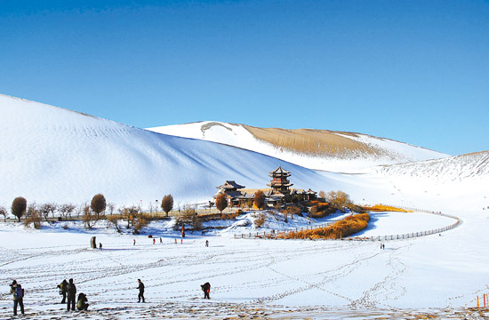 1月17日,游客在甘肃省敦煌市鸣沙山月牙泉景区欣赏大漠雪景.