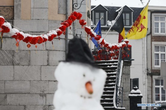 A snowman is seen before the building decorated with Chinese lanterns during the Art Biennale in Theux in eastern Belgium on Jan. 24, 2015. 