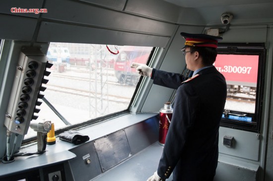 Song Jian points to a signal in the distance to keep himself alerted. He says he performs such gestures more than one thousand times each day. [Photo by Chen Boyuan / China.org.cn]