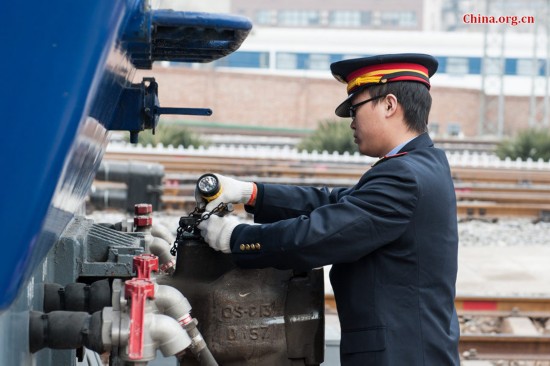 Song Jian performs a visual inspection before the two drivers board the locomotive. [Photo by Chen Boyuan / China.org.cn]