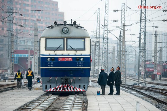 Song Jian (R2) and the train's chief engineer Ding Hailong (R3), receive the daily memo from the dispatcher at the Beijing Railway Authority. [Photo by Chen Boyuan / China.org.cn]