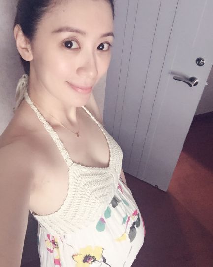 照片中,贾静雯穿着白色的吊带,怀孕6个月四肢仍然纤细,但孕肚已经