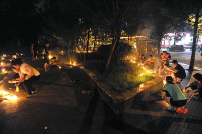 8月26日,中元节临近,许多市民在街道边烧香蜡钱纸祭奠先人.