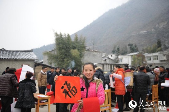 一位小女孩拿著書法家們寫的“福”字，十分開心。