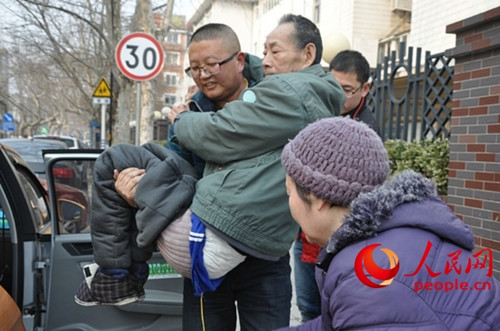 15:43,的哥蔡庆明从出租车上将卢桂富老人抱到事先准备好的轮椅上.