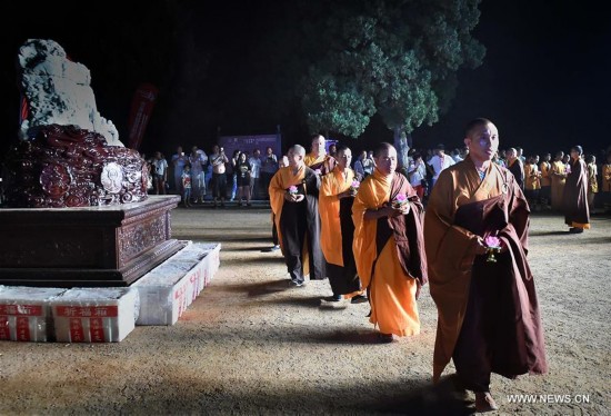 Monks carrying lotus-pattern lamps attend a buddhist ritual at the Shaolin Temple on the Songshan Mountain in Dengfeng City, central China's Henan Province, Aug. 13, 2016.