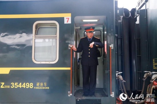 列車即將發車，客運段工作人員宋喜臣正在對時。今年大年三十，他將奮戰在春運一線。（朱虹 攝）