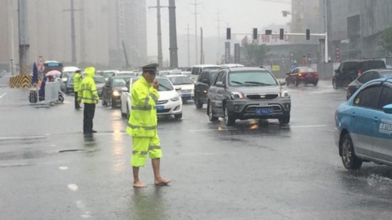 长沙"赤脚哥"交警暴雨中执勤 网友为其点赞