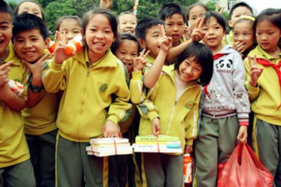 Students in Hechi, Southwest China's Guangxi Zhuang autonomous region, receive gifts given by Xinhuanet and Wahaha Group. [Photo: Xinhua/Zhou Liao]