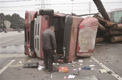 大货车为避让电动车发生侧翻 满车圆木砸向对