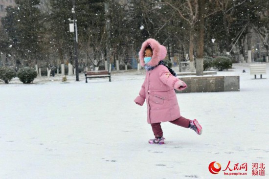 13日石家庄迎来立春后首场降雪。图为一名小