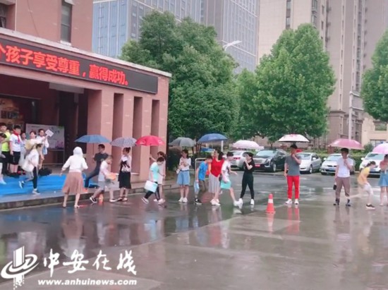 暖心！大雨中老师给学生撑起一片天