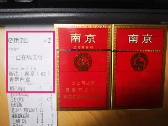 記者在餓了么外賣APP上成功購買的香煙及隨單小票