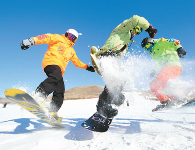 在内蒙古兴安盟突泉县宝石滑雪场,三位单板滑雪爱好者正尽情玩耍.