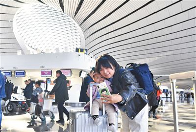 昨日,北京大兴国际机场,一名乘客在机场航站楼内和宝宝自拍.