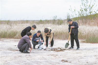 图为南京农业大学经济管理学院“盐碱之克”学生科技团队队员指导当地农民和农技人员进行取土、测土。新华社发（周社根摄）