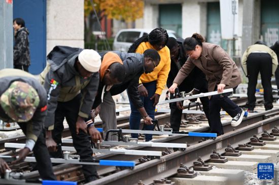 在天津铁道职业技术学院，老师指导几内亚学员使用铁路轨距尺（11月11日摄）。新华社记者 李然 摄