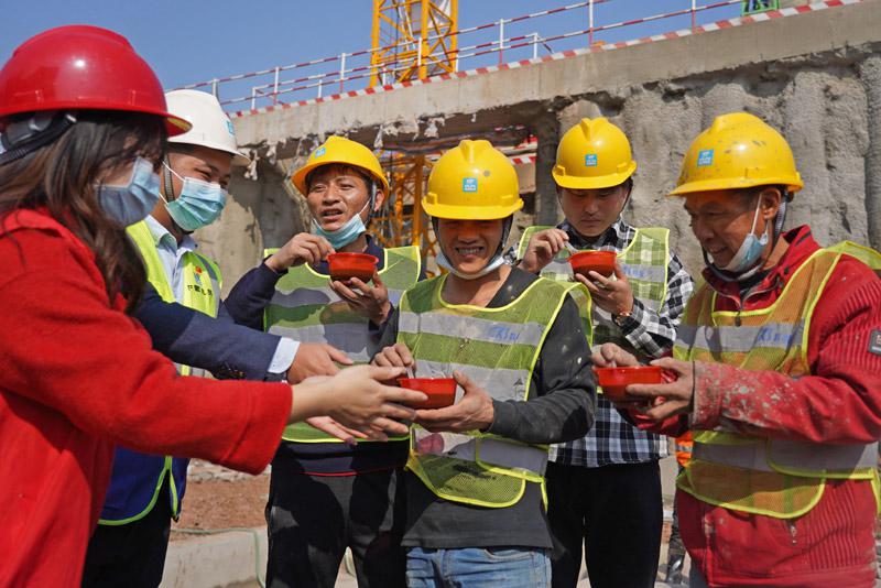 1月20日,在位于江西南昌红谷滩新区的一处建筑工地,志愿者与工作人员