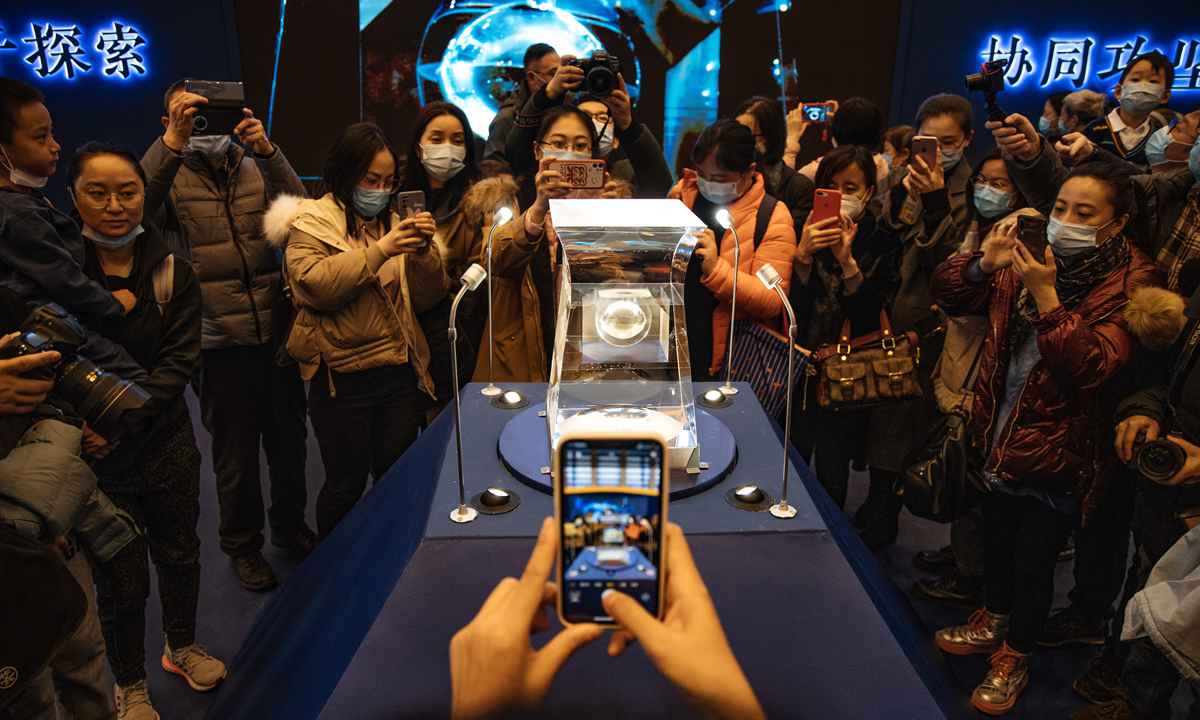 Visitors take photos of soil samples from moon retrieved by the Chang'e-5 lunar lander in December 2020, which went  on display at the National Museum of China in Beijing on Sunday. Scientific and technological objects related to the lunar exploration project are also on display at the exhibition. Photo: Li Hao/GT