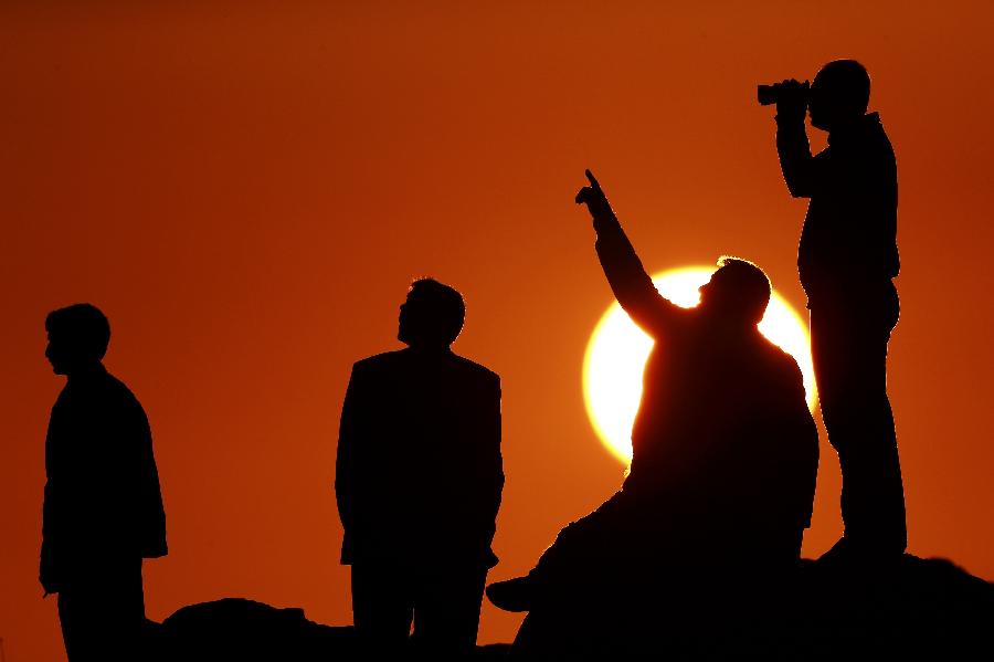 People watch from a hill during sunset after an U.S.-led coalition airstrike on Kobane, Syria, as seen from the Turkish side of the bordeR, near Suruc district, Sanliurfa, Turkey, 18 October 2014. 