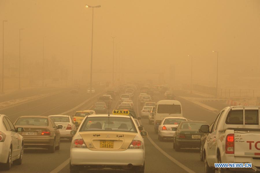 Vehicles run in a sandstorm in Kuwait City, capital of Kuwait, Oct. 20, 2014. 